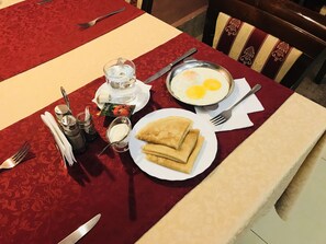 Enjoy a delicious breakfast spread with eggs, yogurt, and crepes.