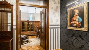 Una habitación con un armario de madera, una silla, una mesa y un cuadro en la pared.