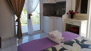 Un dormitorio con cama, baño y kitchenette.