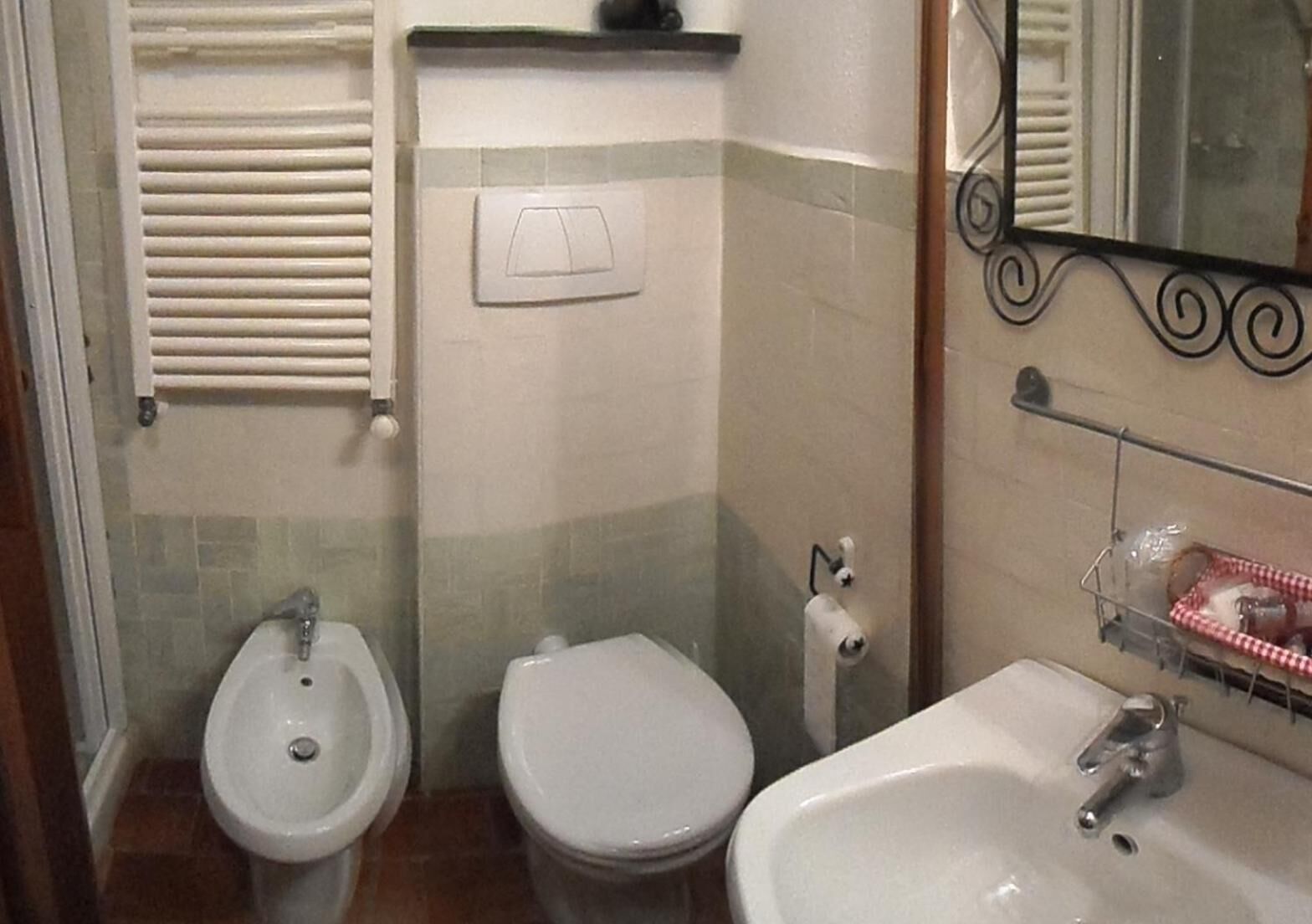 Une salle de bain avec deux toilettes, un lavabo et un miroir.
