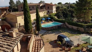 Une villa avec piscine, un espace extérieur aménagé et une voiture garée à proximité.