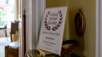 A framed award plaque for 'The Good Hotel Guide Editor's Choice 2025' placed on a table.