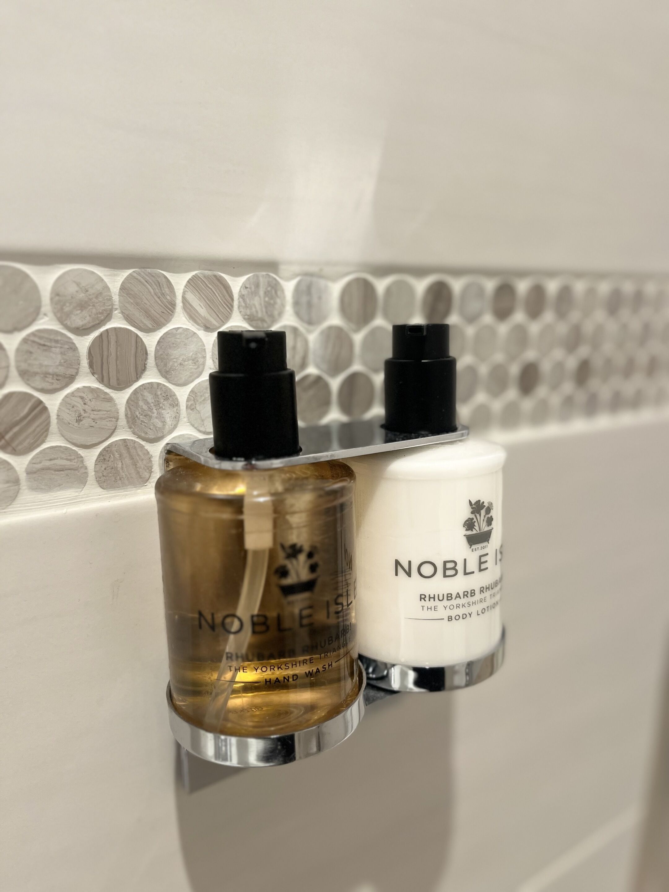 Two bottles of hand lotion on a bathroom counter.