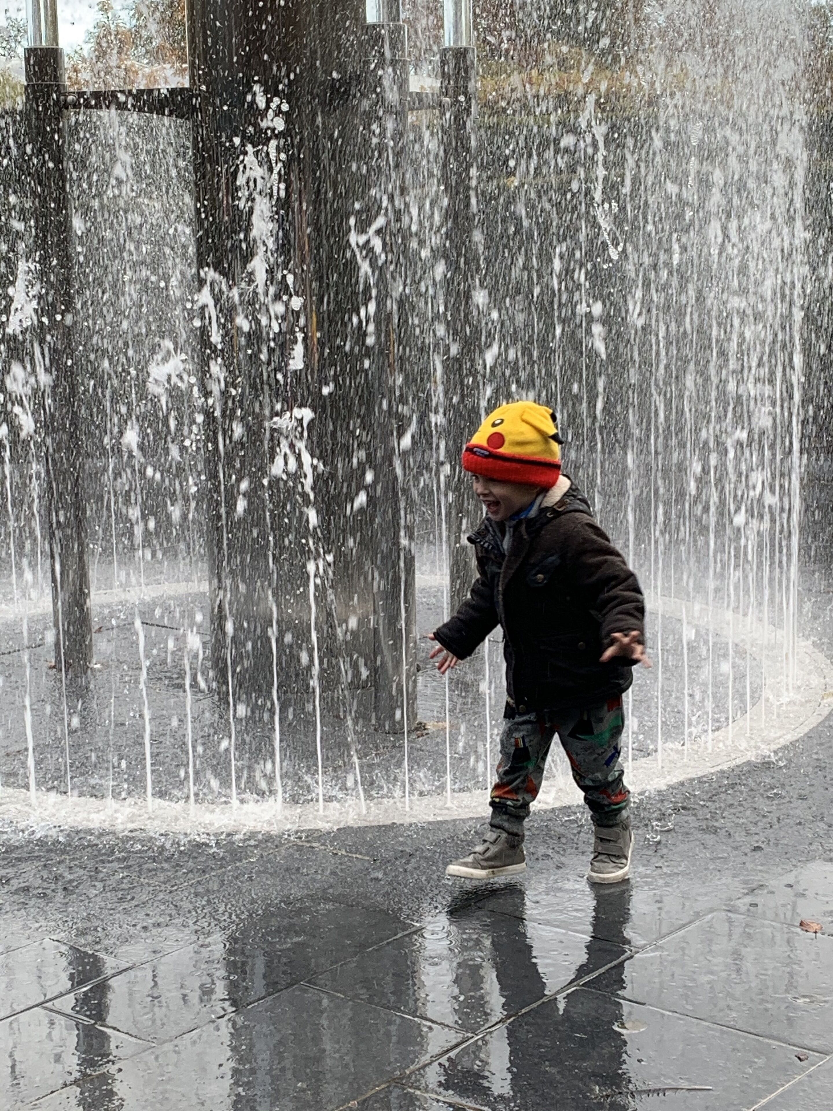 A child playing in a water fountain area.