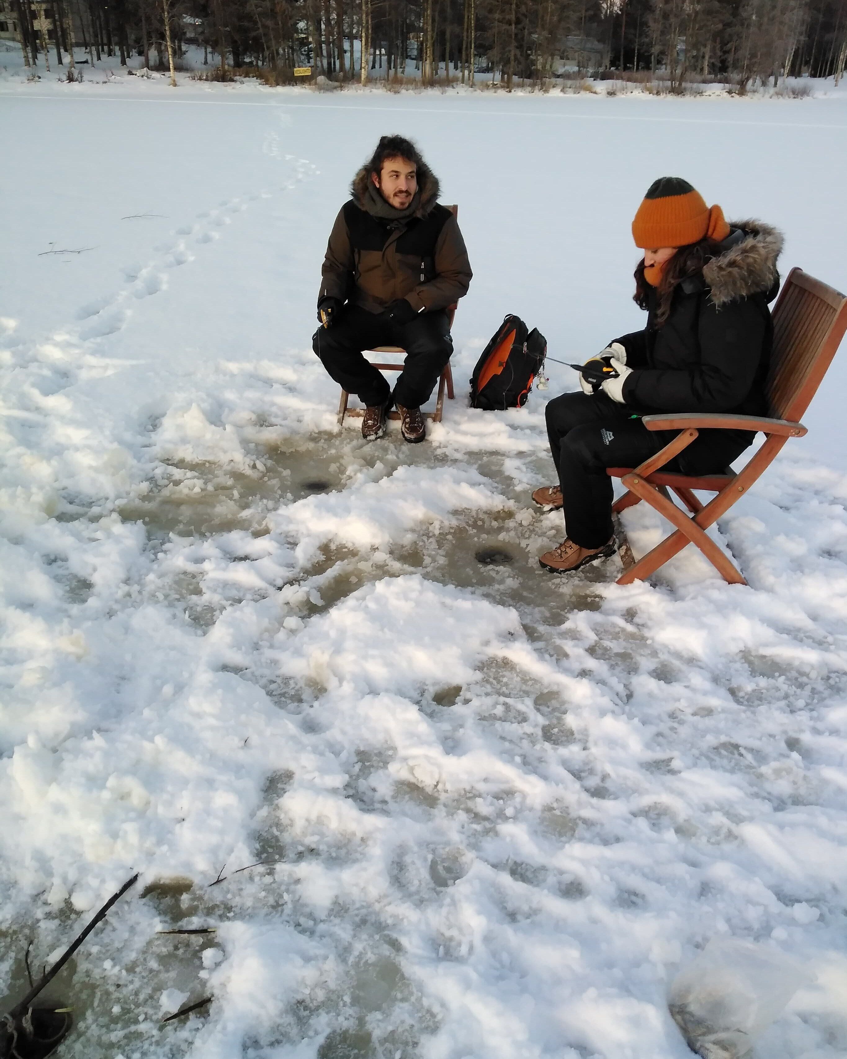Dos personas sentadas en sillas en un entorno nevado al aire libre.