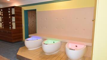 Baño público con tres orinales, un armario de madera y un revestimiento acolchado.