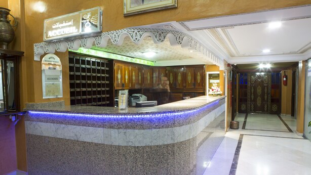 A hotel reception area with a marble counter, a reception desk, and a decorative ceiling. - Hôtel Résidence Amalou (Marrakech)