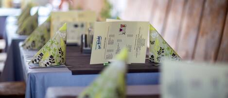 A row of tables with menus and a wooden backdrop.