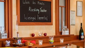 A buffet area with a chalkboard menu, wooden cabinets, and various food items. - Hotel zur Brücke (Minheim)