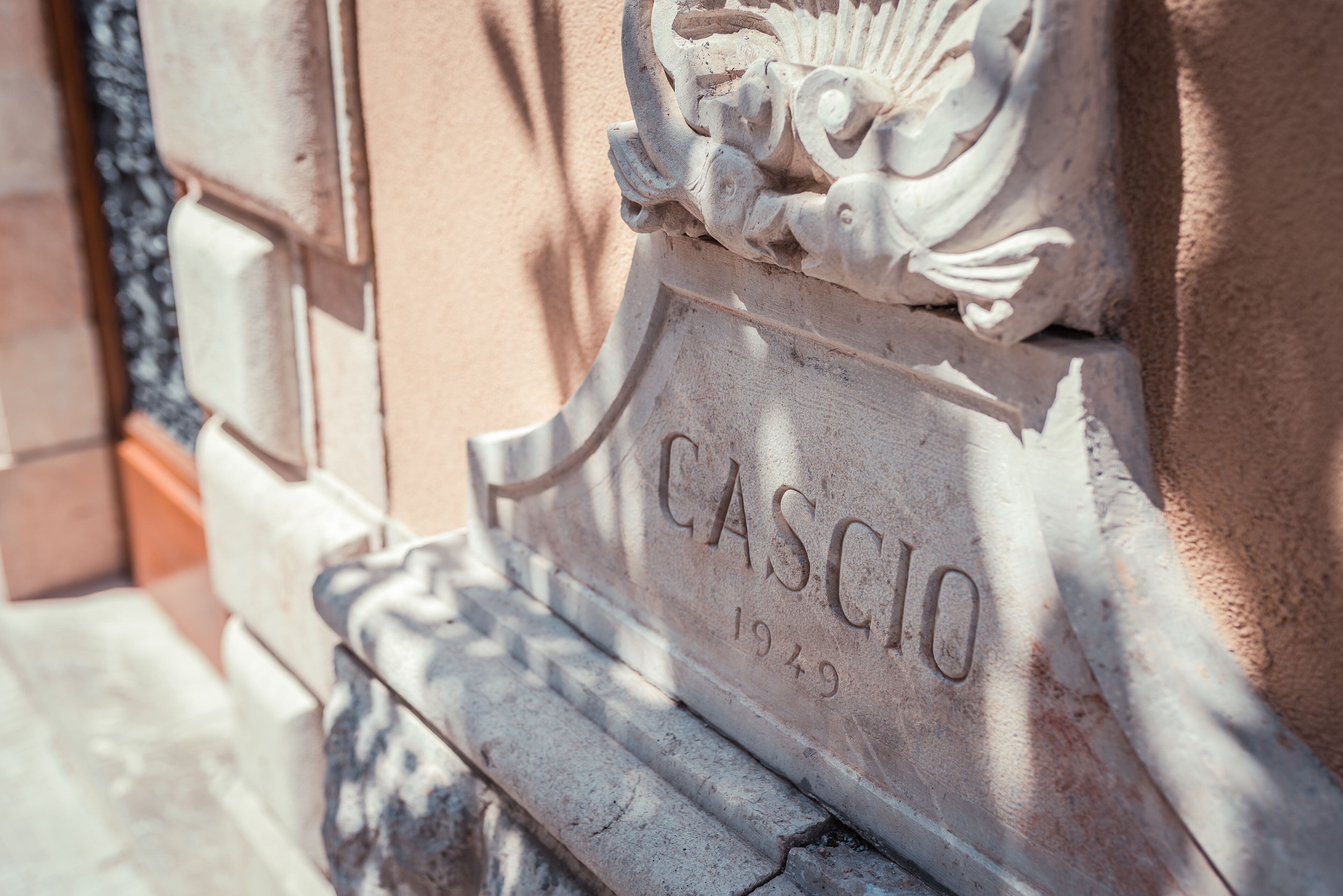 A stone plaque with the name "CASCIO" and the year "1949" engraved on it.