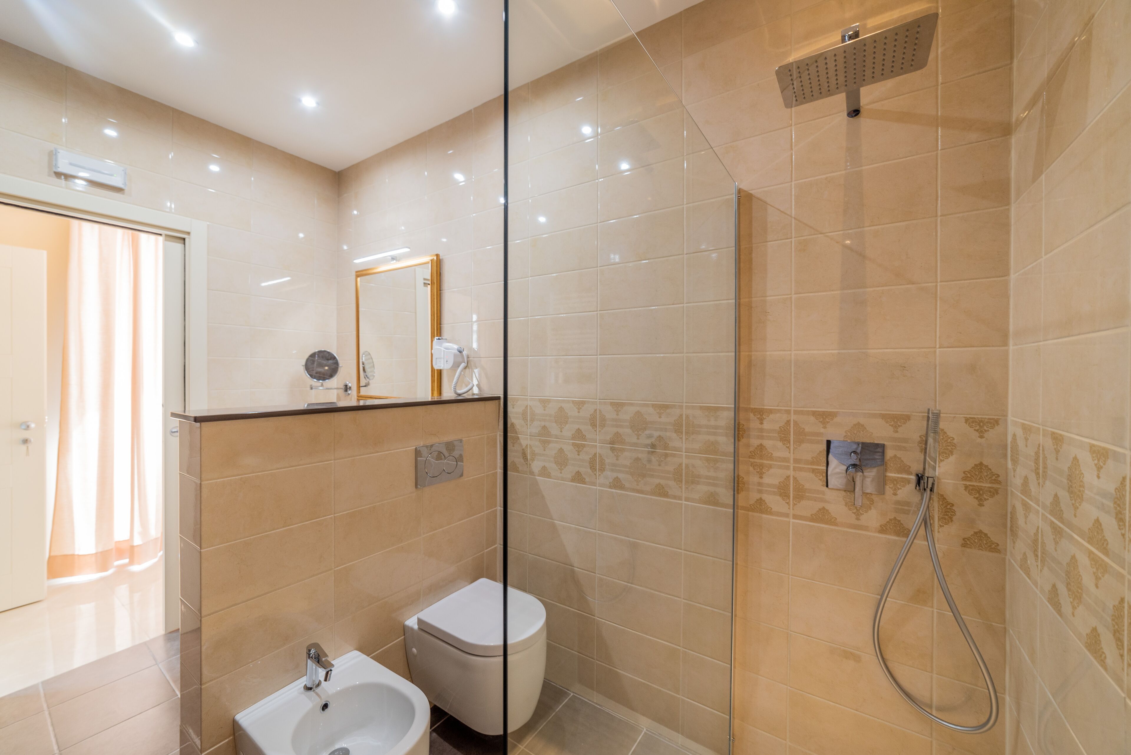 Un baño moderno con cabina de ducha de vidrio, inodoro y lavamanos.