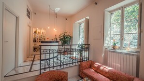 Una sala de estar acogedora con un sofá, una mesa de centro y una escalera que lleva a una zona de cocina.