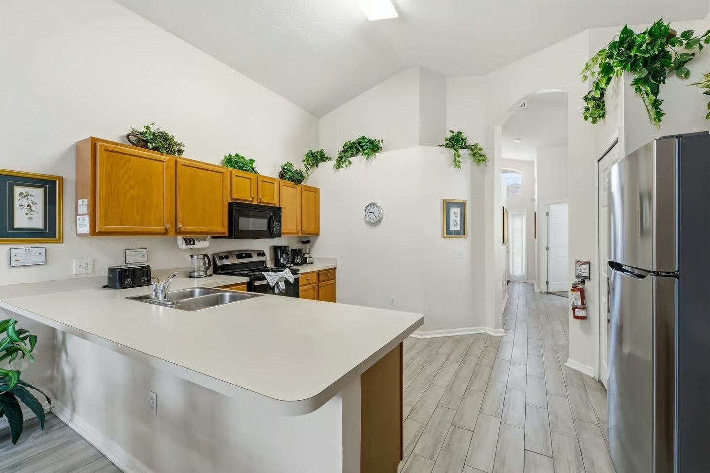 A modern kitchen with wooden cabinets, a stainless steel refrigerator, and a central island.