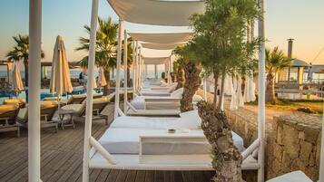 Alberca al aire libre, sombrillas en la alberca y camastros