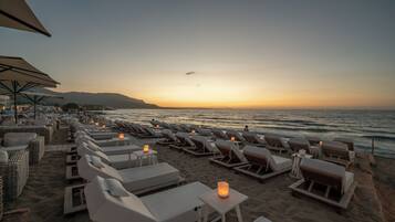 On the beach, sun-loungers, beach umbrellas, rowing