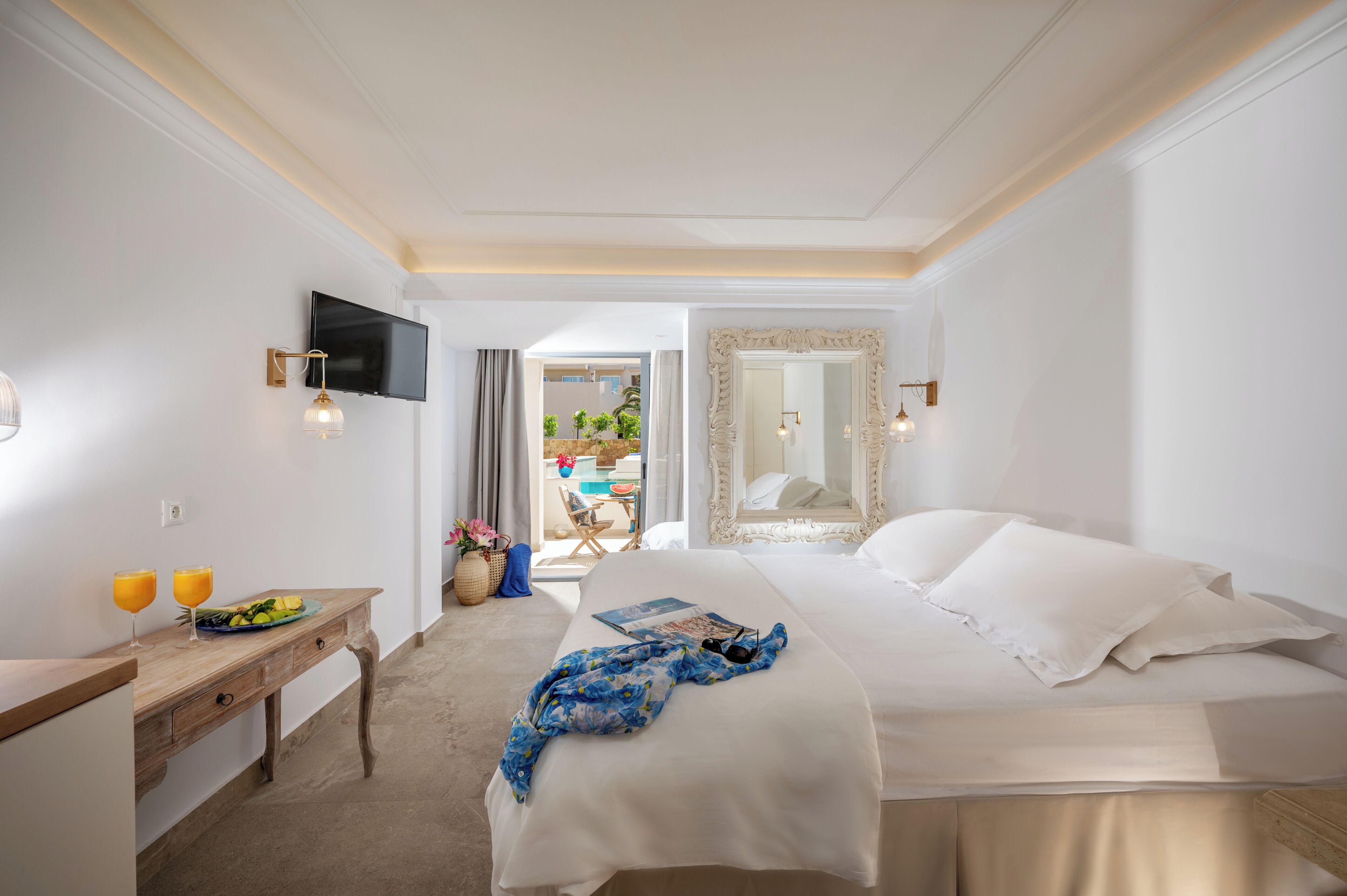 Habitación de hotel con cama, escritorio, ordenador portátil, televisión y vistas al exterior.
