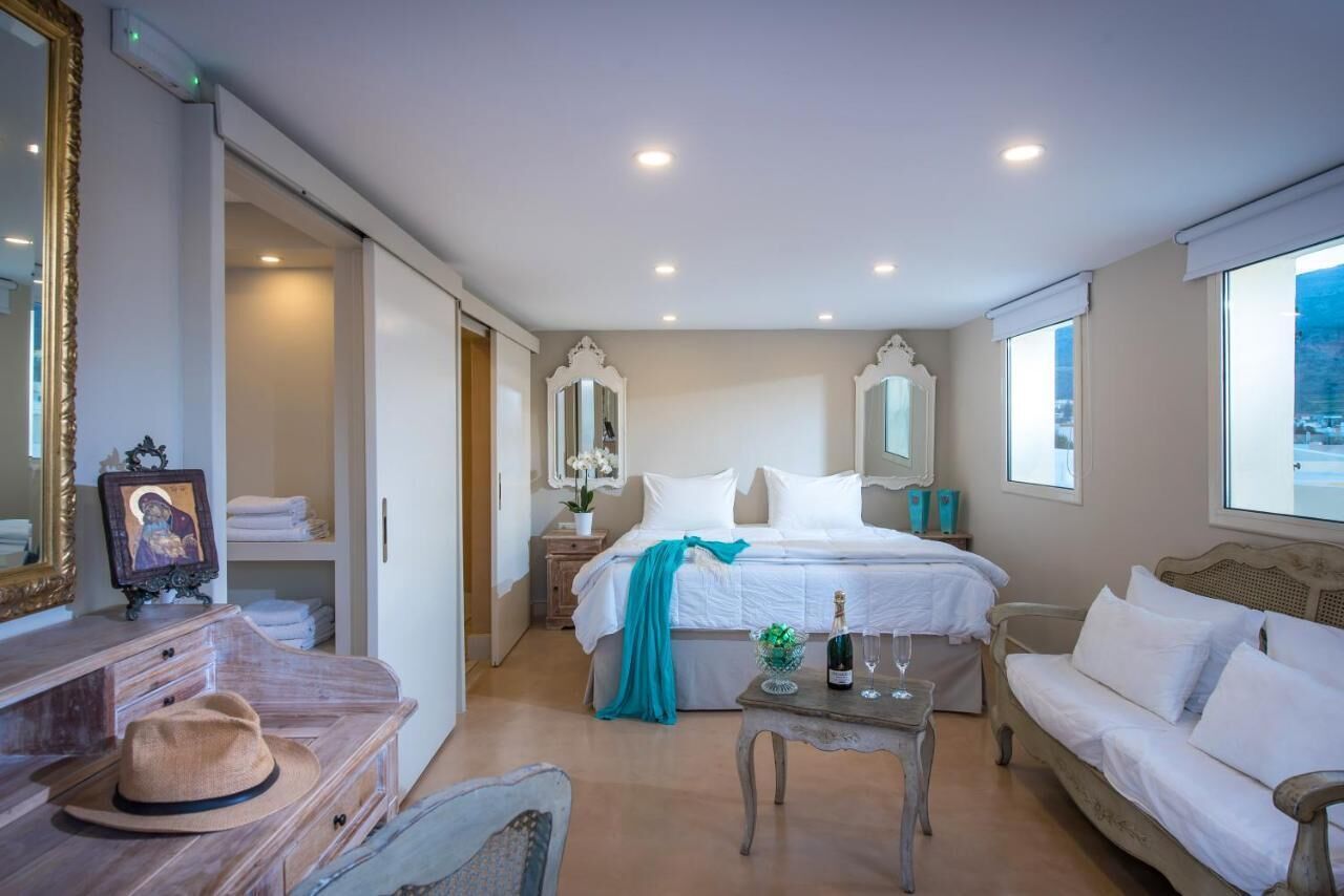 A bedroom with a bed, bedside tables, a dresser, a mirror, and a window.