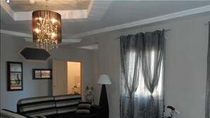 A living room with a sofa, ottoman, and a chandelier. - B&B Lolly (Mileto)