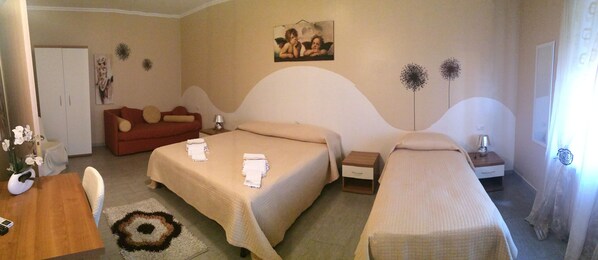 A hotel room with two beds, a sofa, a small table, and a decorative rug. - B&B Lolly (Mileto)