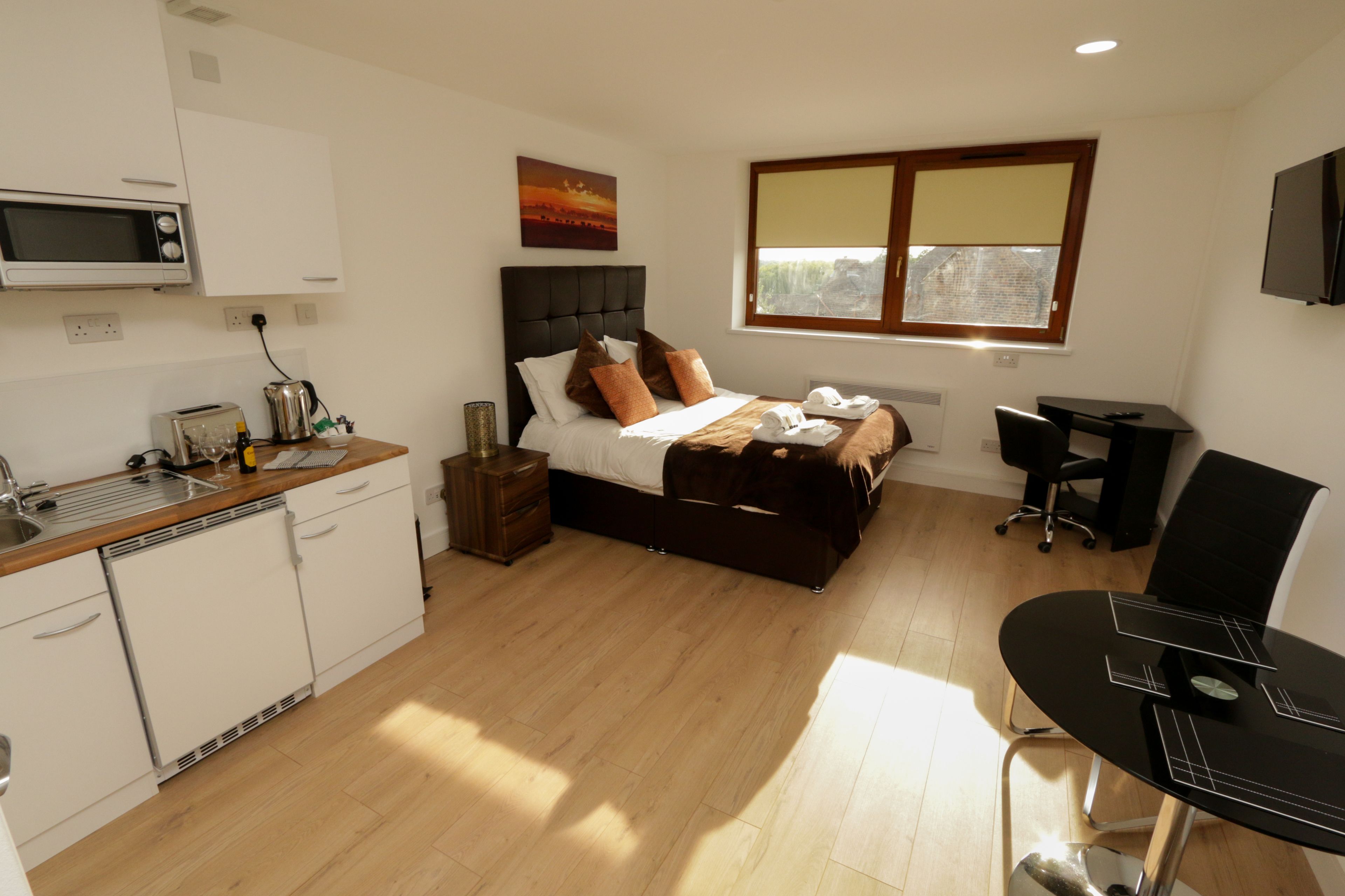A bedroom with a bed, bedside table, and a window.