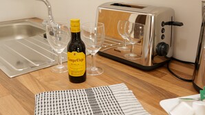 A kitchen with a toaster, a bottle of Campo Viejo Rioja, two wine glasses, and a checkered cloth. - Trafalgar House (Stoke-on-Trent)