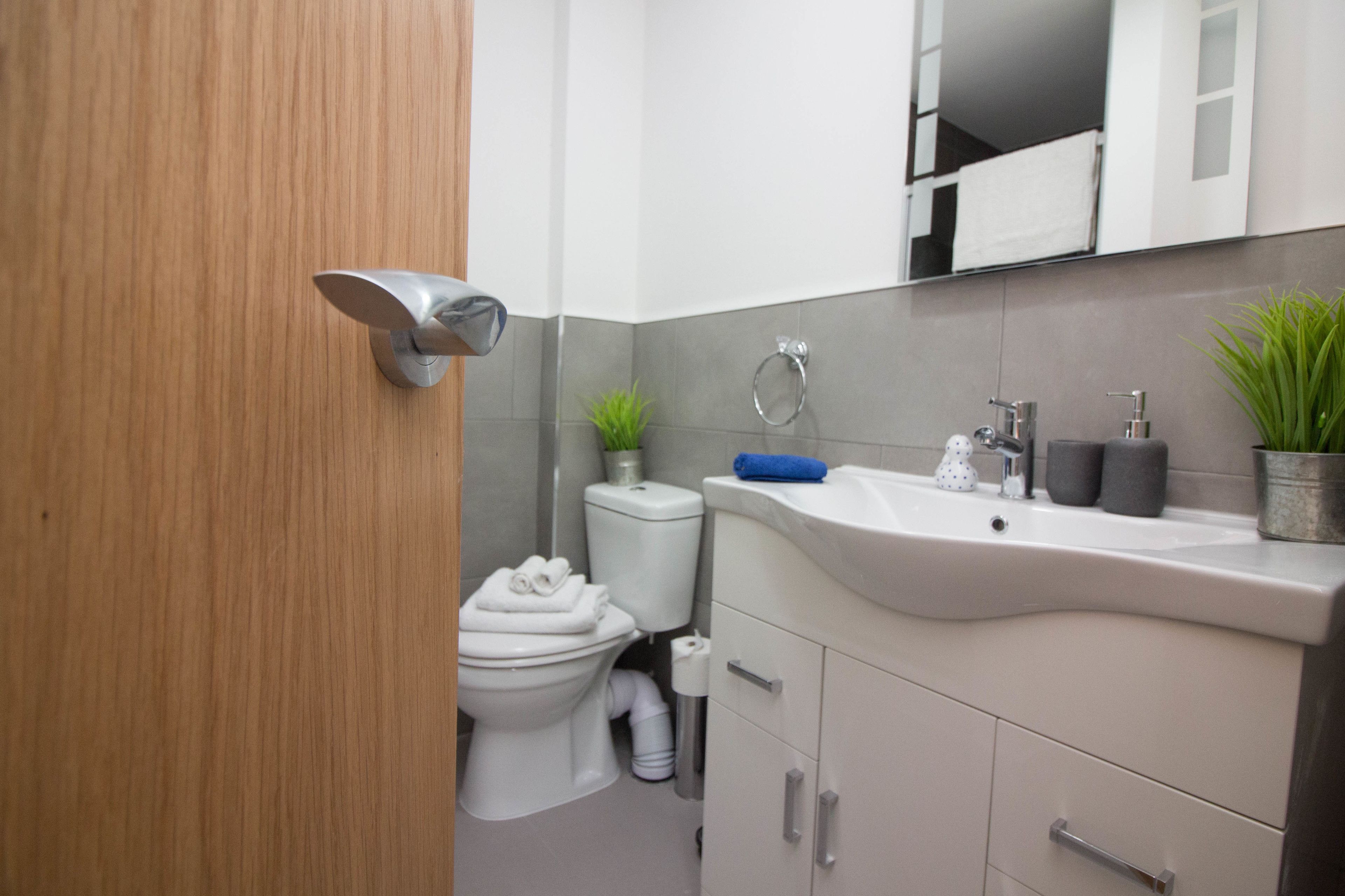 Ein modernes Badezimmer mit Toilette, Waschbecken und Spiegel.