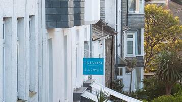 A row of terraced houses with a blue sign indicating a business.