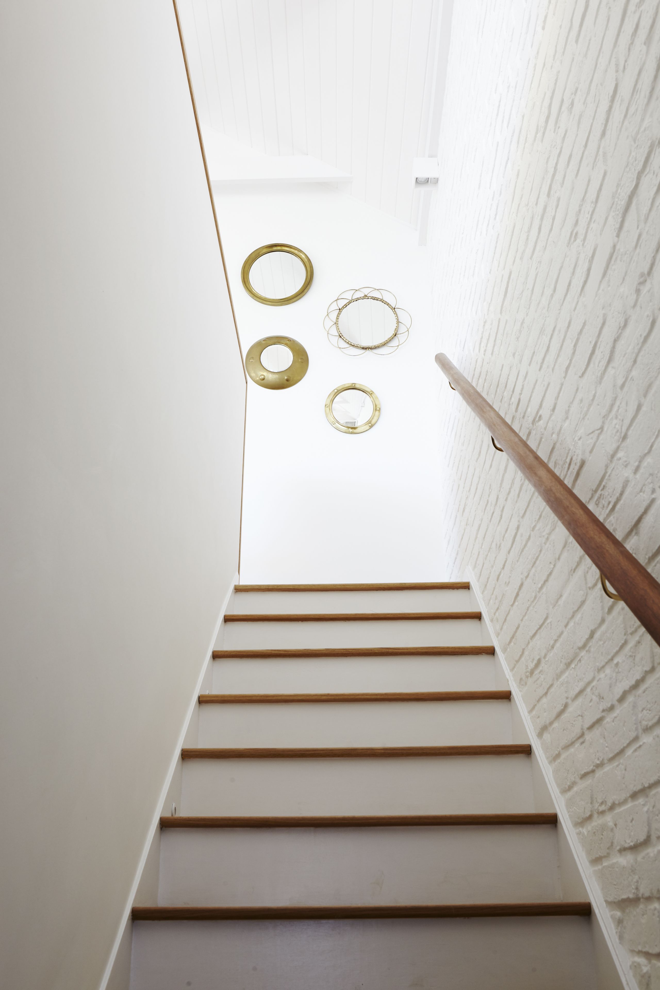 A staircase with wooden steps and a white wall on one side.