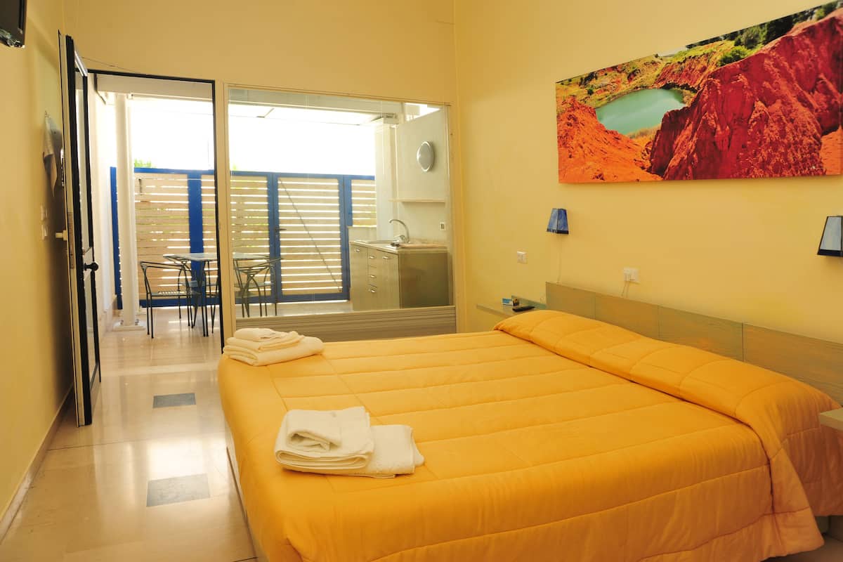 Una habitación de hotel con cama, baño y balcón con vistas a un lago.