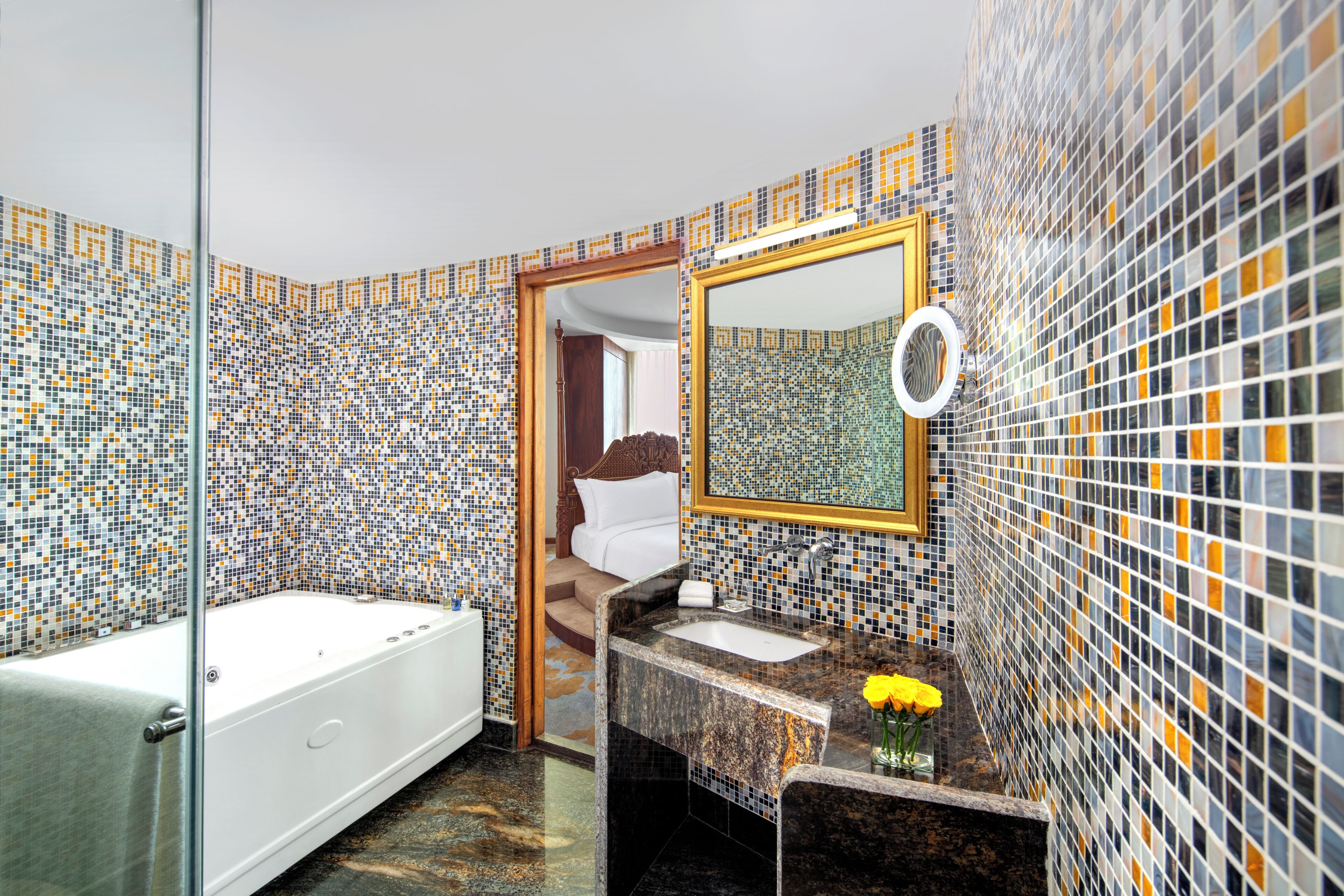 A bathroom with a bathtub, a sink with a mirror, and a shower area.