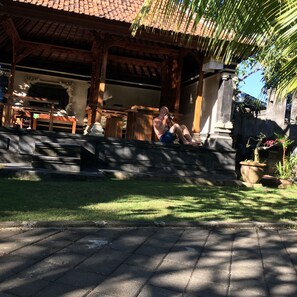 A traditional building with a tiled roof and wooden pillars. - El Homestay Bali (Kutuh)