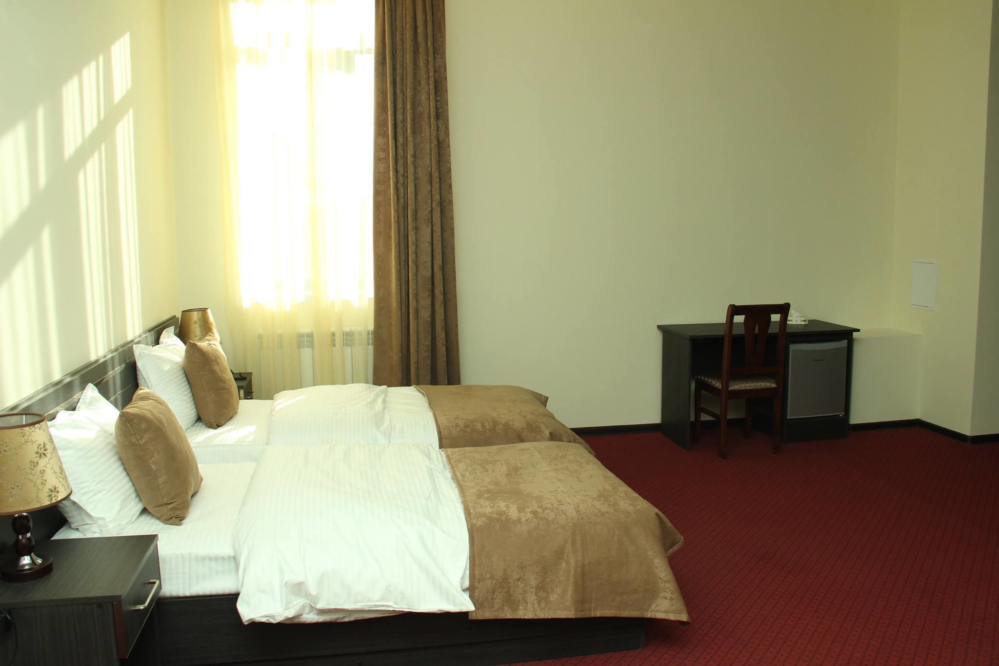 A hotel room with a bed, a desk, and a chair.