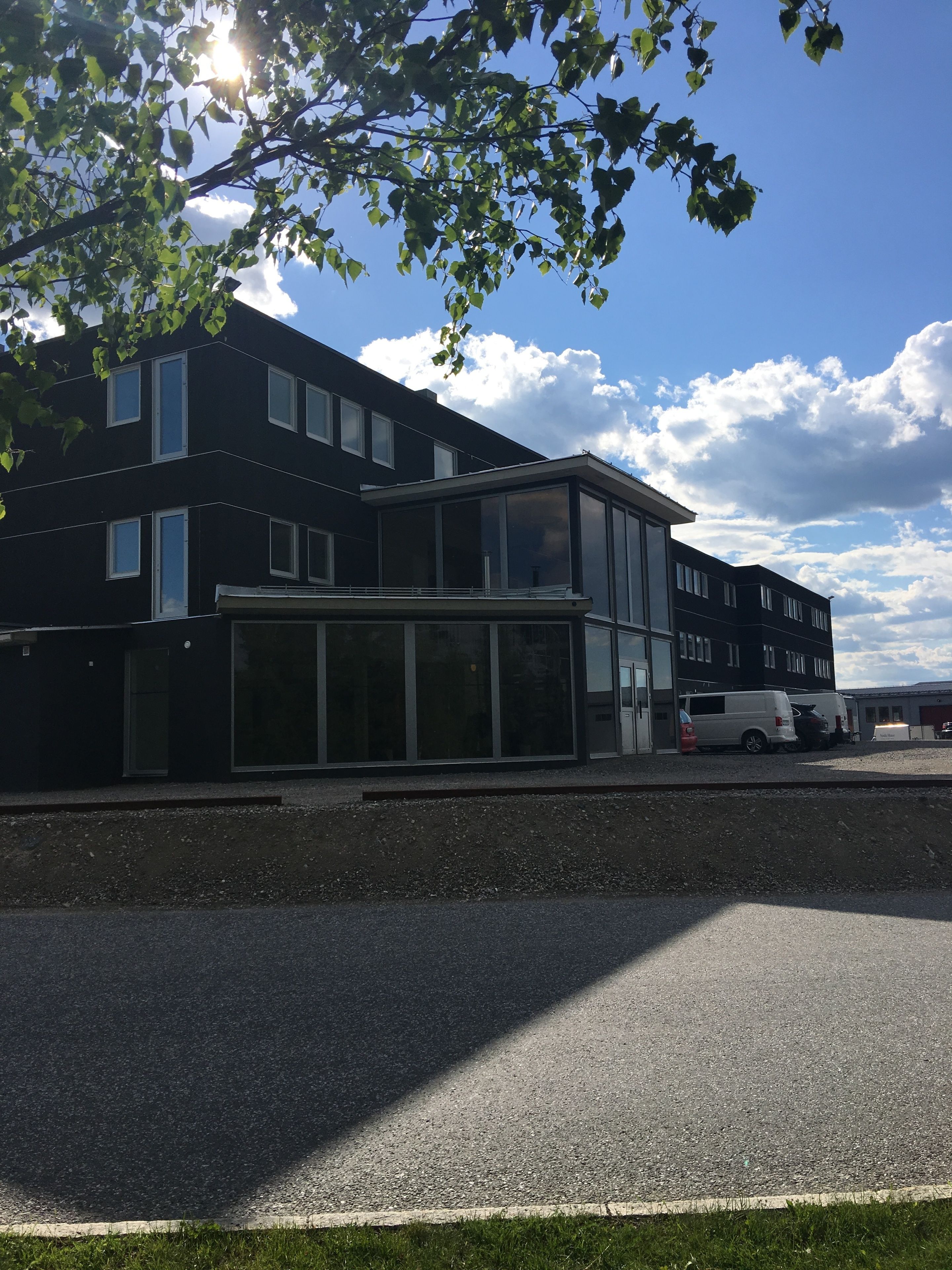 Moderni rakennus, jossa on suuret ikkunat ja tasakatto.