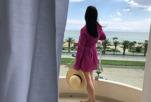 Un balcón con vista a la playa y palmeras.