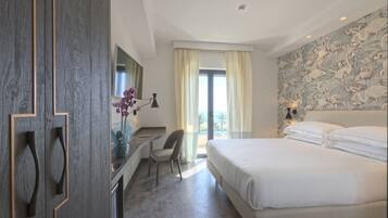 Una habitación de hotel con cama, escritorio, silla, espejo y ventana con cortinas.