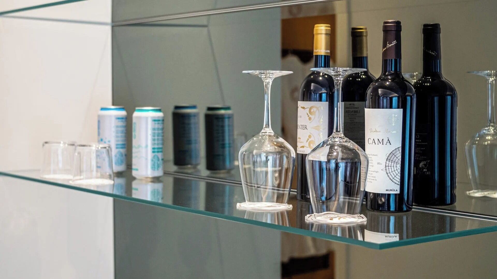 A glass display case with wine bottles and glasses.