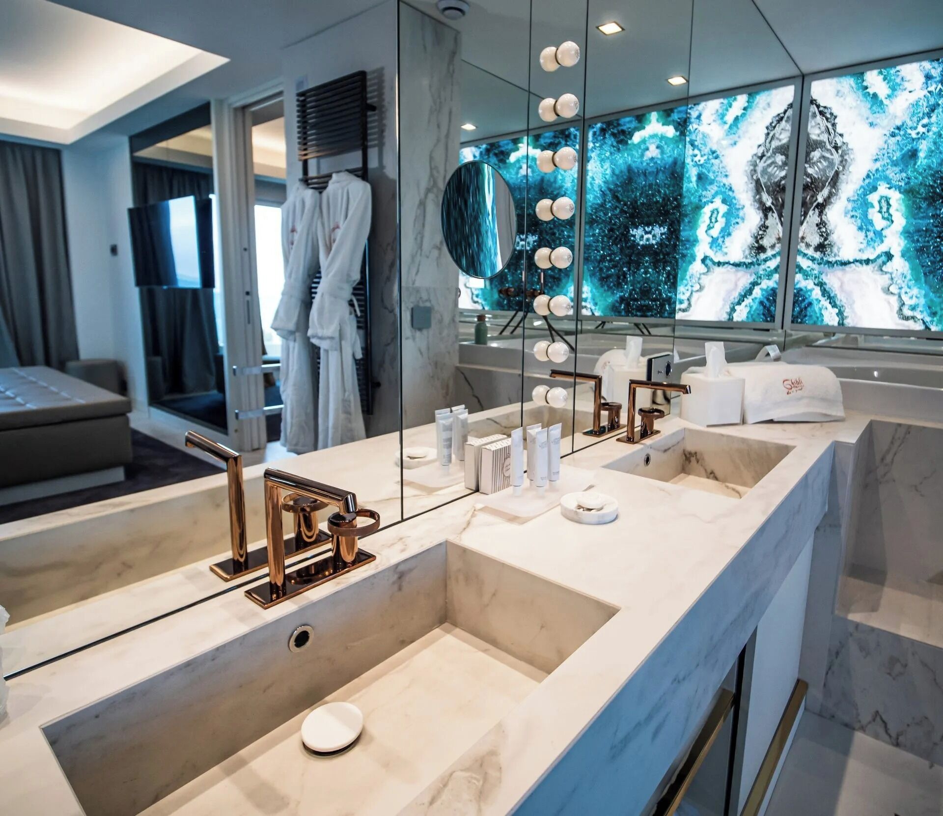 Un baño moderno con un tocador amplio, lavamanos dobles y un espejo grande.