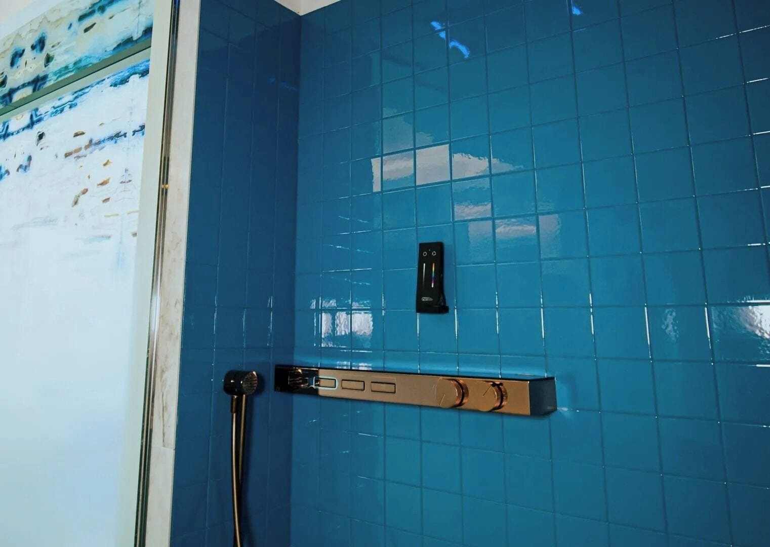 Un baño con azulejos azules, una ducha y un perchero.