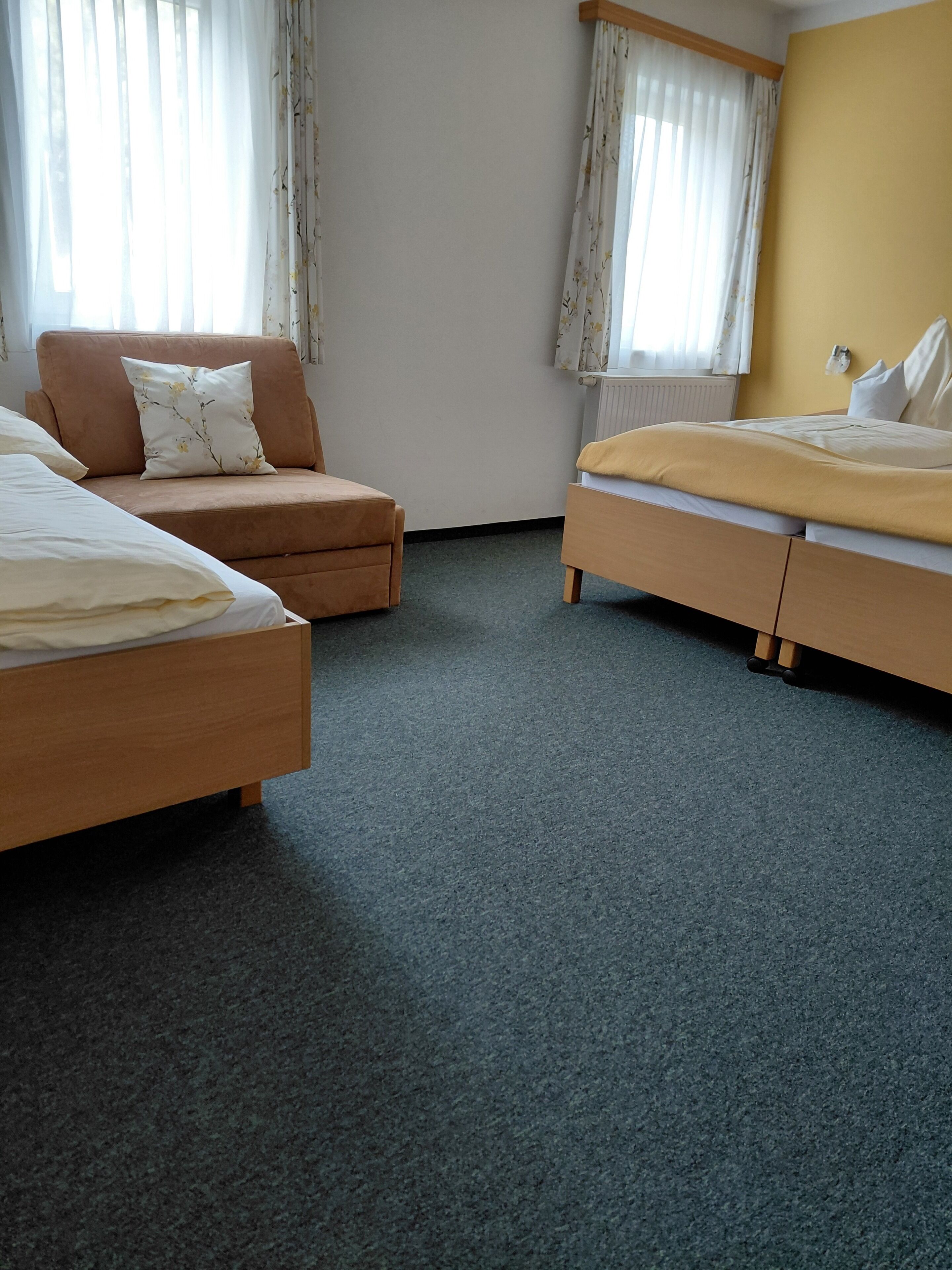 A hotel room with a bed, a sofa, and a chair.