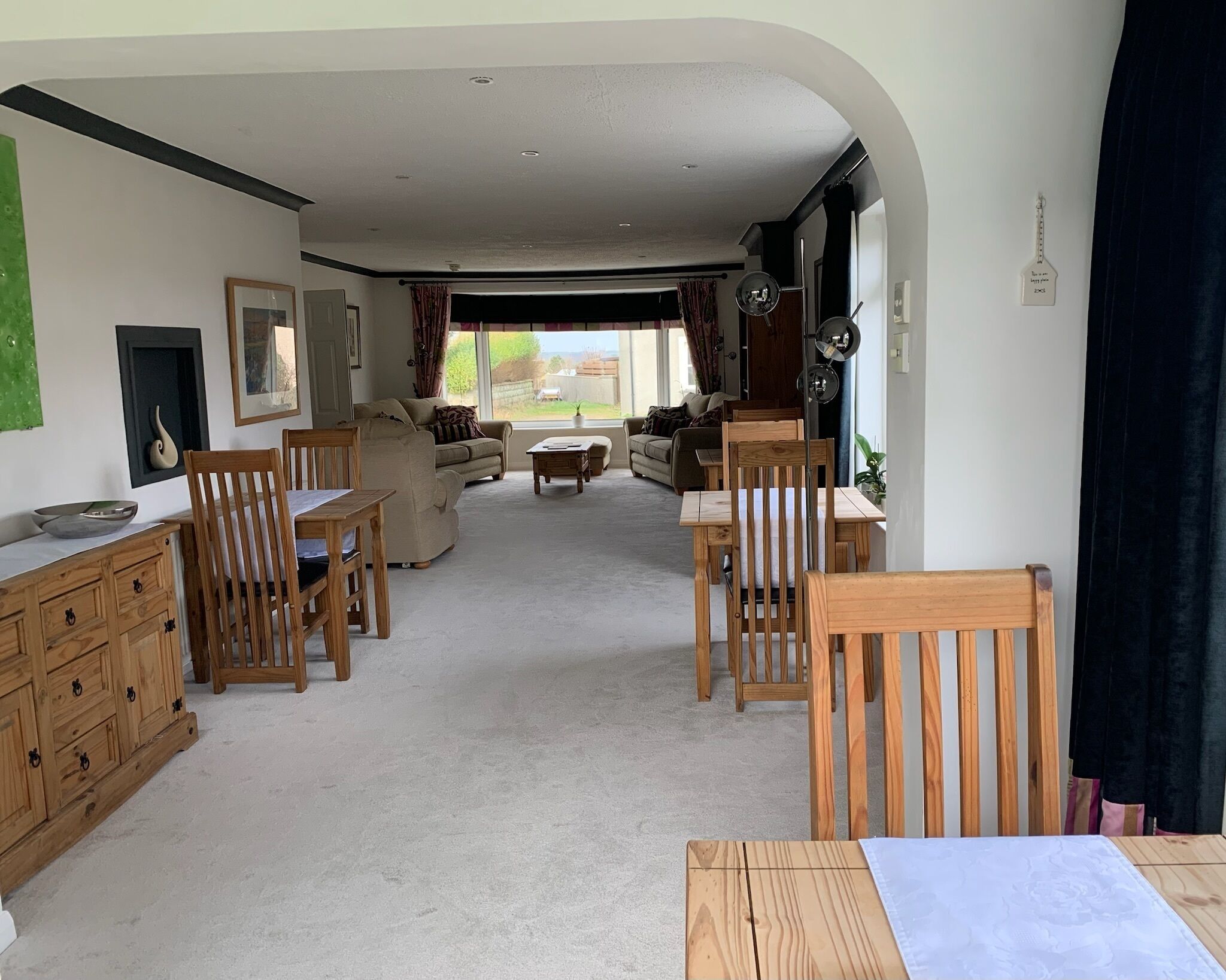 A spacious living area with a dining table and chairs, a sofa, and a coffee table.