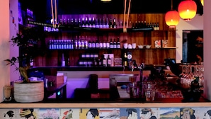 A traditional Japanese bar with wooden signage, hanging lanterns, and a wall of ukiyo-e woodblock prints. - Barabas - Hostel (Lucerne)