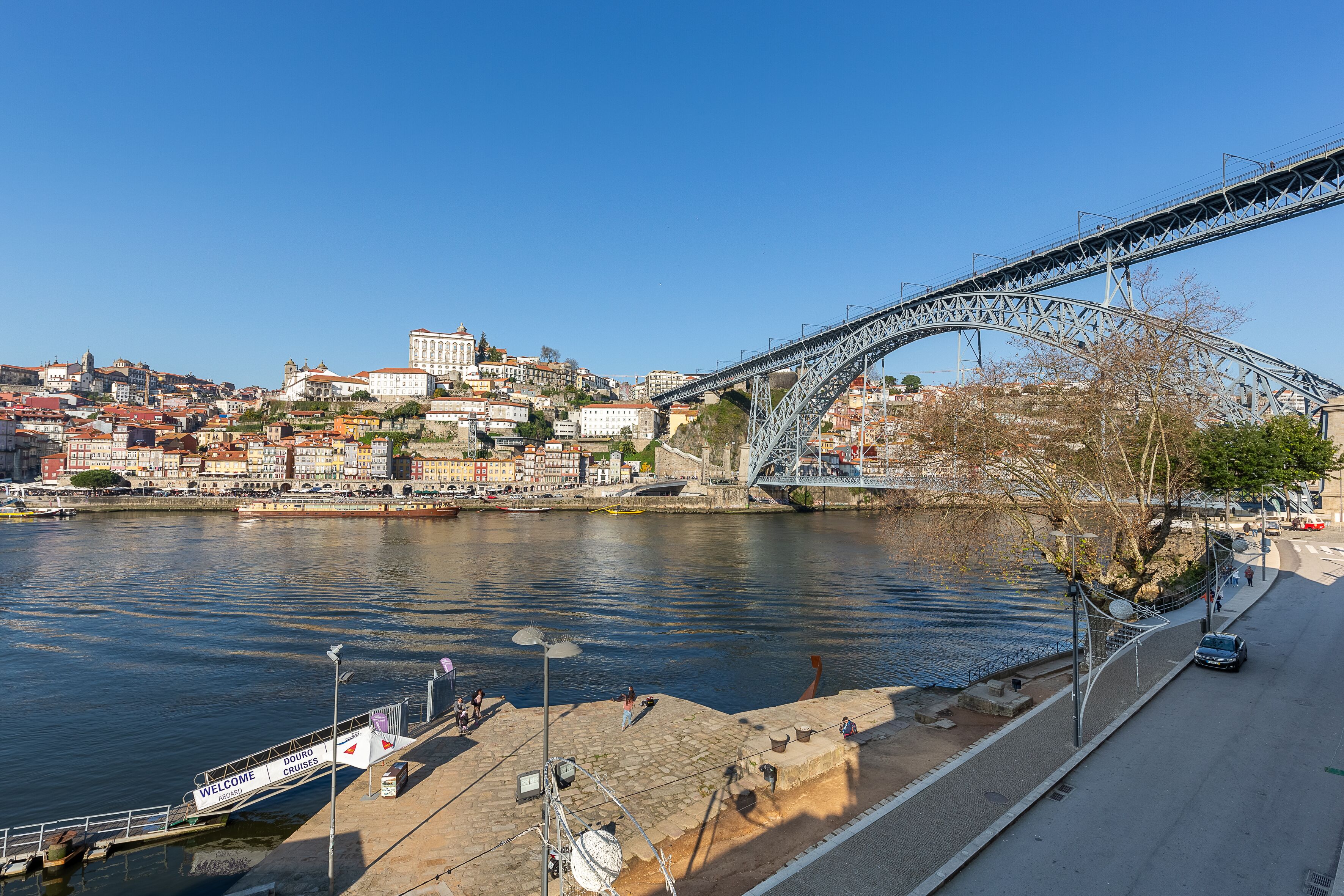 A river with a bridge, a dock, and a cityscape in the background.