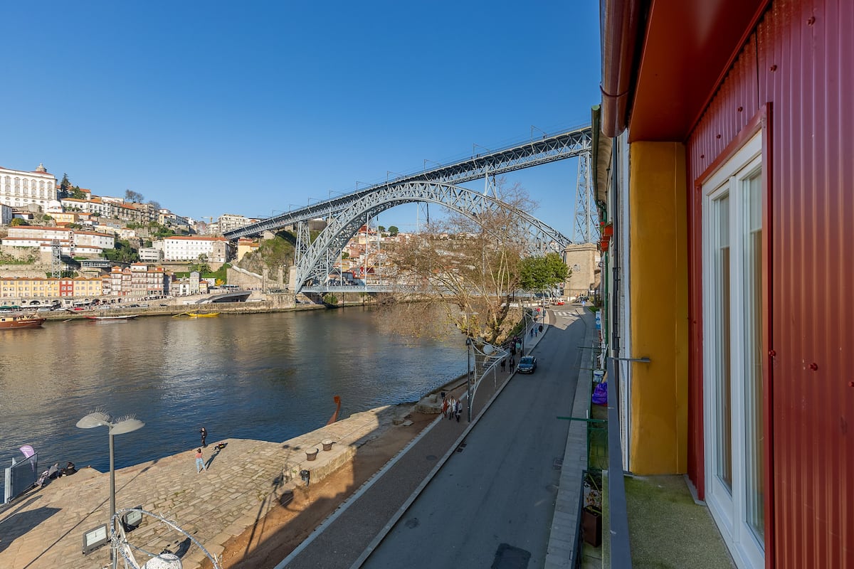 Une rivière avec un pont, des bâtiments et un trottoir.