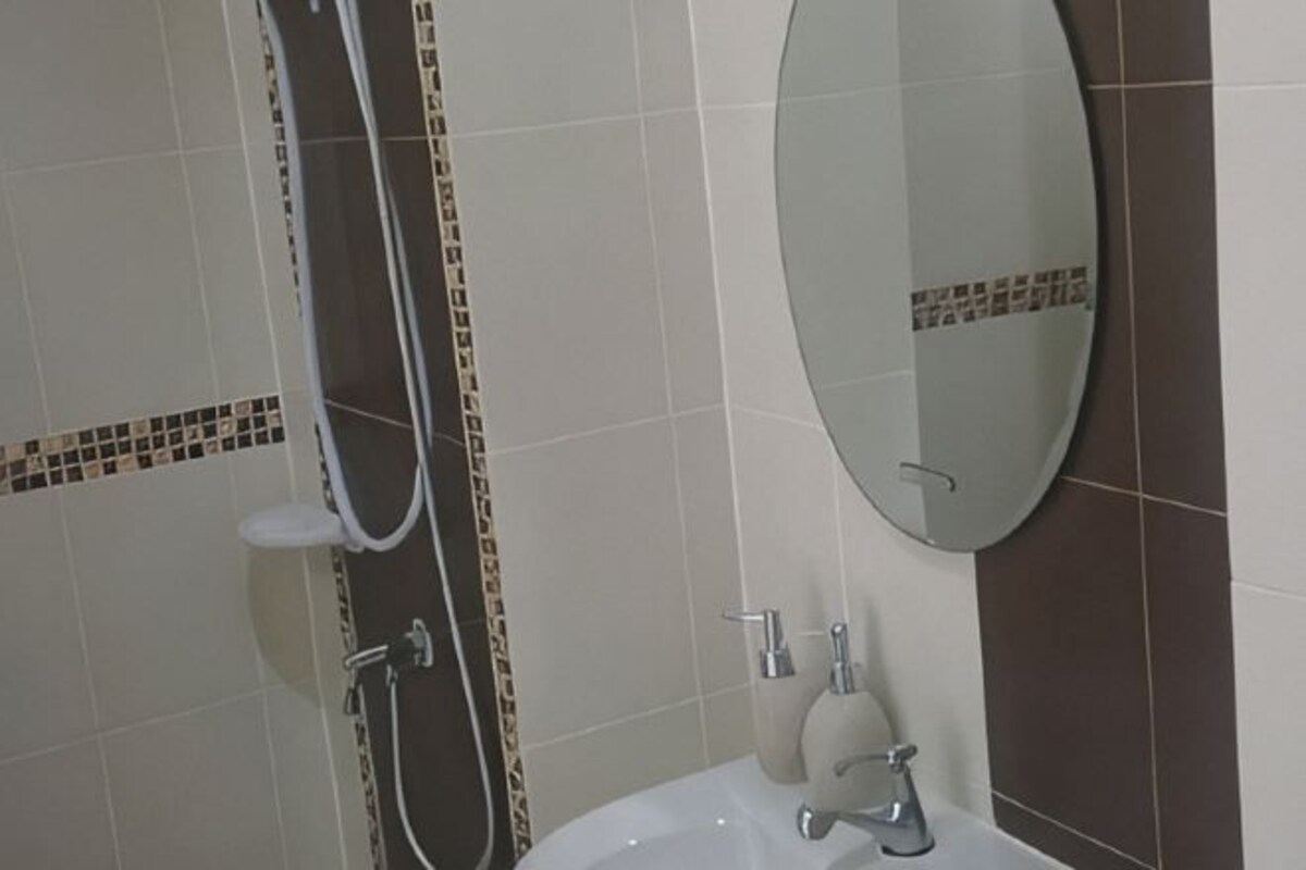 A bathroom with a bathtub, a shower, a sink, and a mirror.