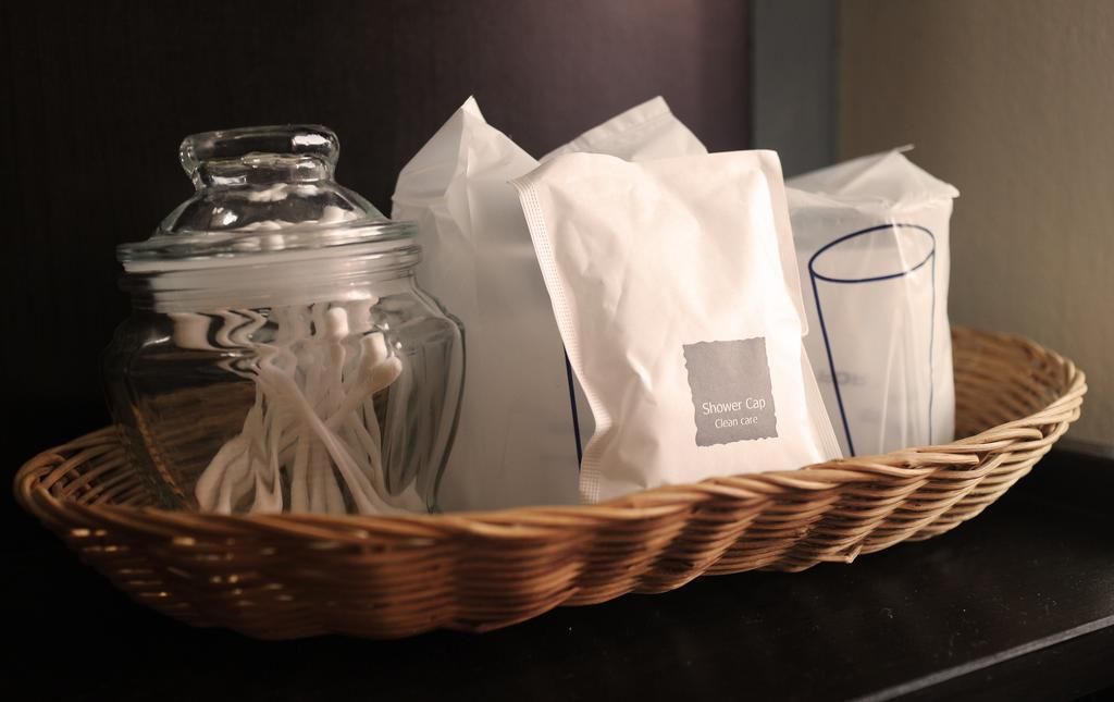 Una cesta de mimbre con un tarro de vidrio, un paño blanco y una bolsa blanca con etiqueta.