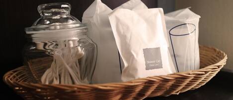 Una cesta de mimbre con un tarro de vidrio, un paño blanco y una bolsa blanca con etiqueta.