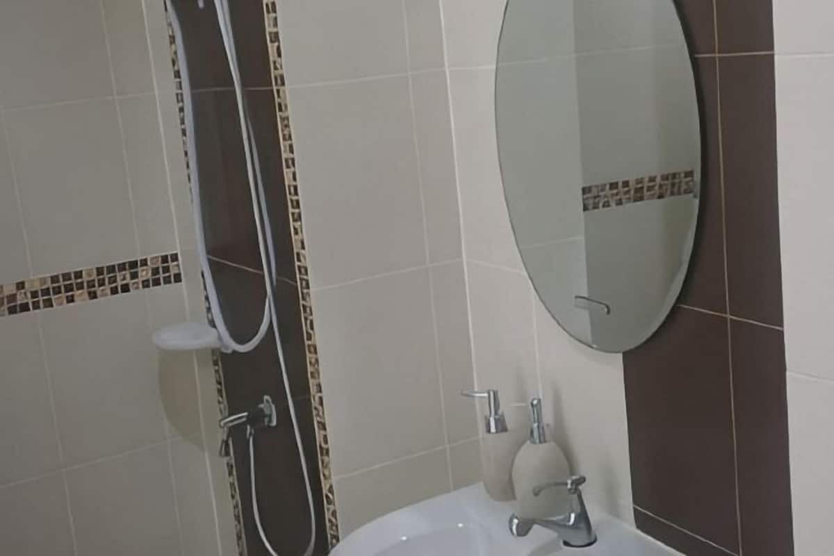 A bathroom with a bathtub, a shower, a sink, and a mirror.