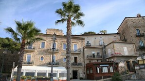 A historic building with multiple balconies and a cobblestone plaza. - Palazzetto Florio (Castellabate)