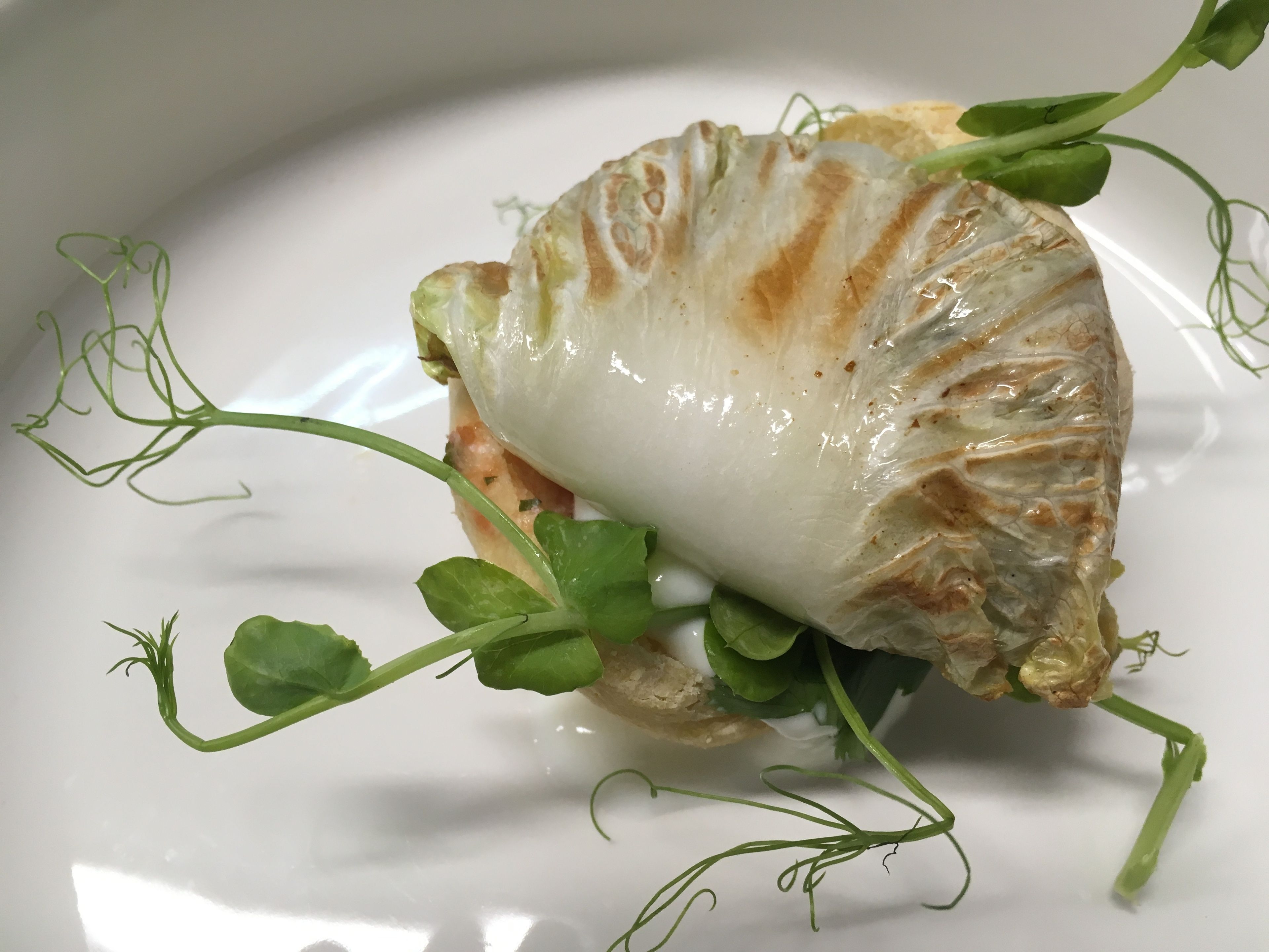 Un plato con hojaldre y vegetales verdes.