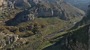 Un paisaje montañoso con acantilados rocosos y un río.